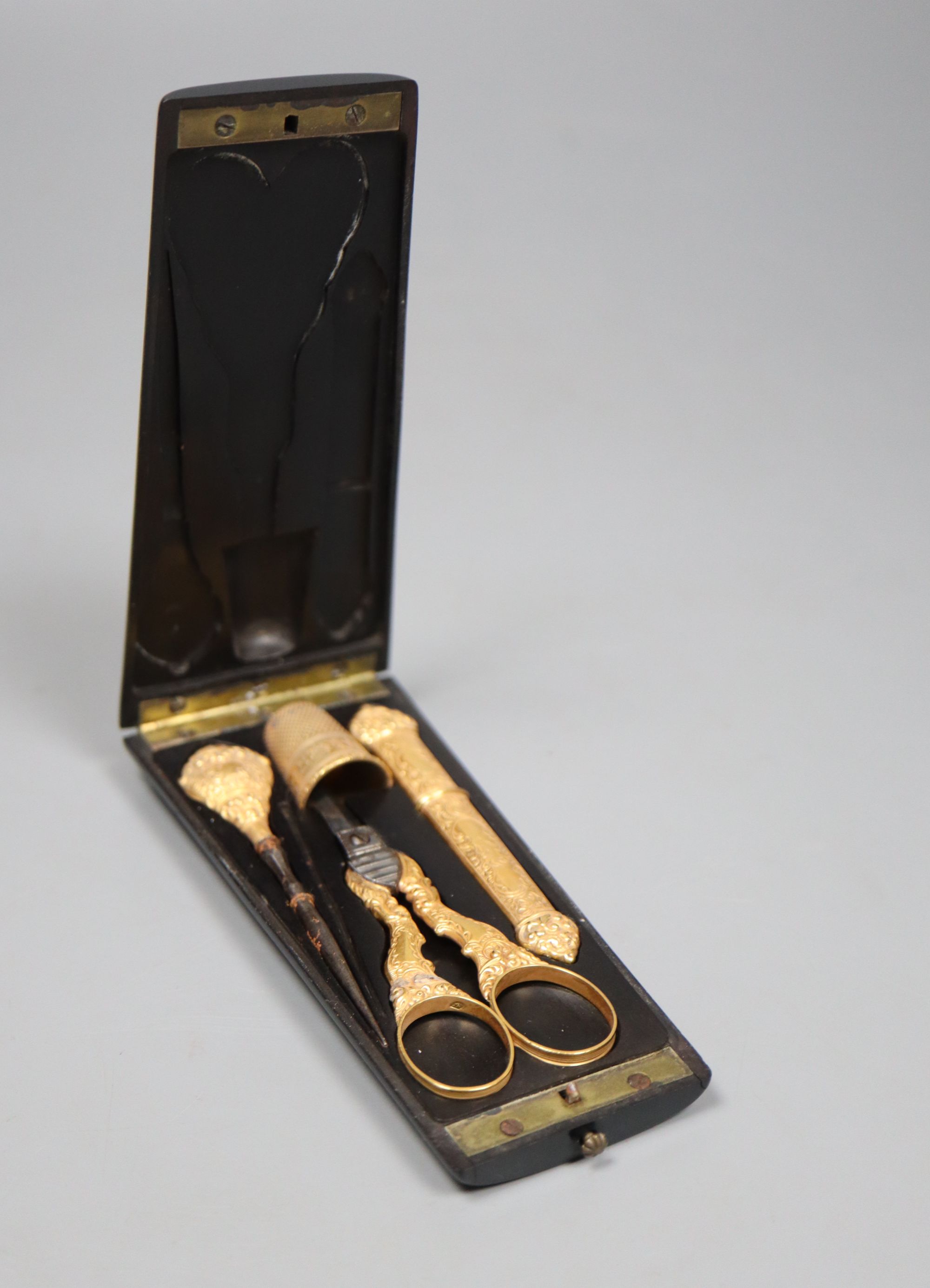 A cased 19th century French yellow metal three piece necessaire, with later associated metal thimble,